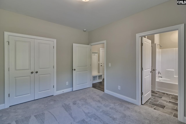 unfurnished bedroom with a closet, baseboards, carpet, and connected bathroom