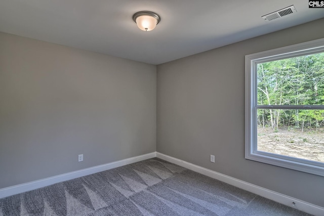 spare room featuring carpet flooring, baseboards, and visible vents