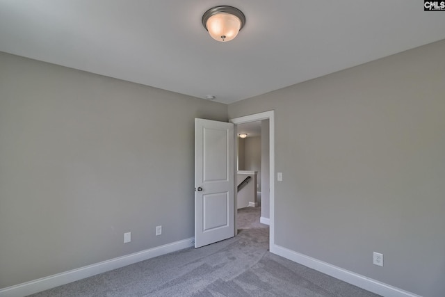 unfurnished room with carpet flooring and baseboards