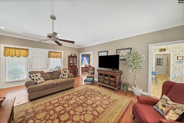 living area with crown molding, baseboards, and wood finished floors