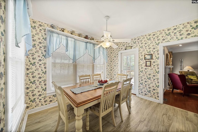 dining area featuring light wood finished floors, wallpapered walls, baseboards, and a ceiling fan