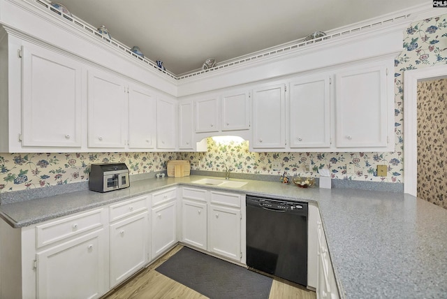 kitchen with white cabinets, wallpapered walls, black dishwasher, and a sink