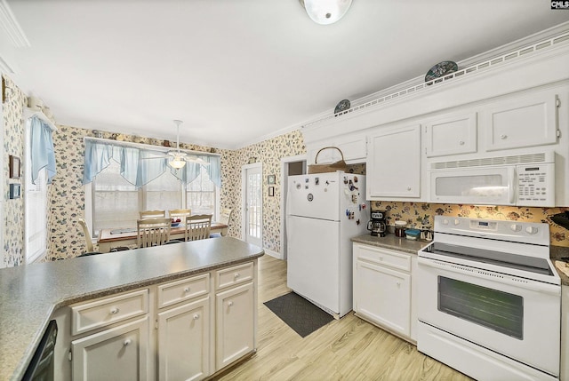 kitchen featuring light wood finished floors, white appliances, wallpapered walls, and decorative light fixtures