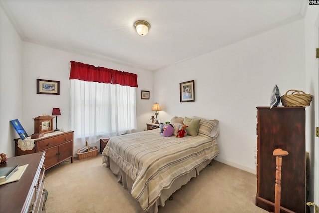 bedroom with light colored carpet and baseboards