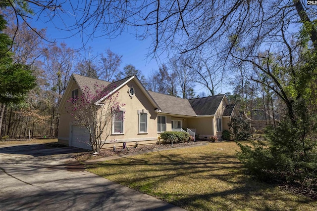 view of property exterior featuring stucco siding, a lawn, and driveway