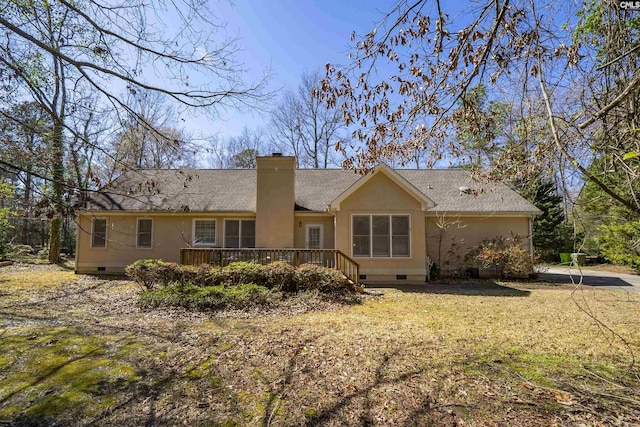 rear view of property featuring stucco siding, a chimney, and crawl space