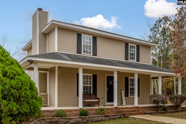 farmhouse-style home with a porch and a chimney