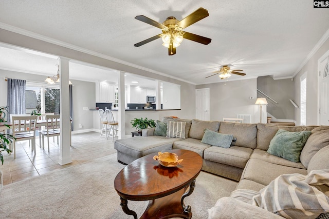 living room with light tile patterned floors, light carpet, a textured ceiling, and ornamental molding