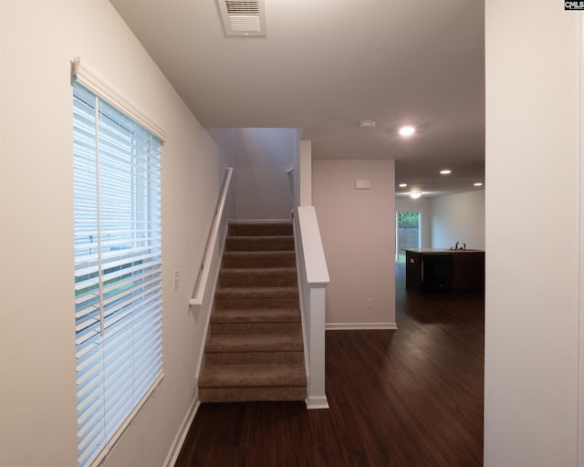 stairs with visible vents, recessed lighting, baseboards, and wood finished floors