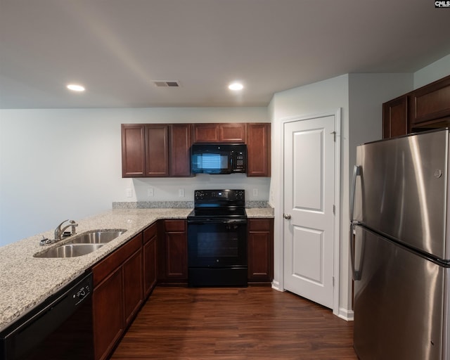 kitchen featuring light stone counters, dark wood-style floors, recessed lighting, a sink, and black appliances