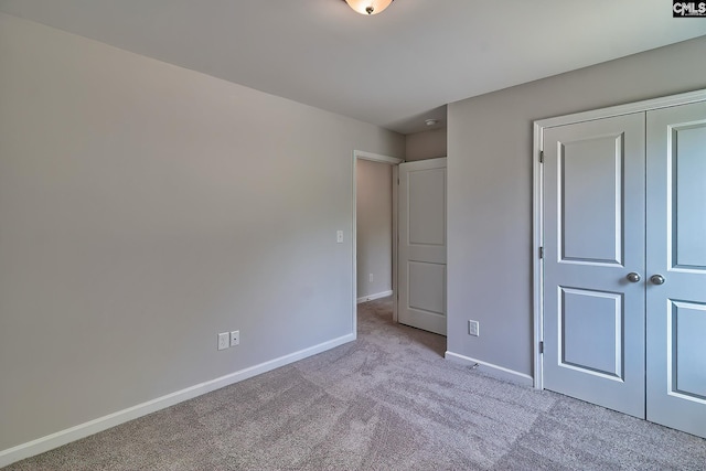 unfurnished bedroom with a closet, baseboards, and carpet floors