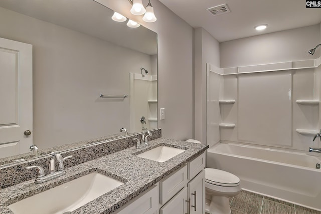 full bathroom featuring a sink, visible vents, toilet, and double vanity