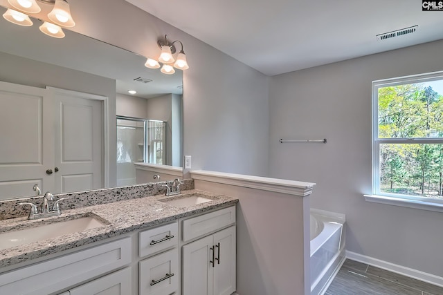 full bath with a healthy amount of sunlight, visible vents, and a sink