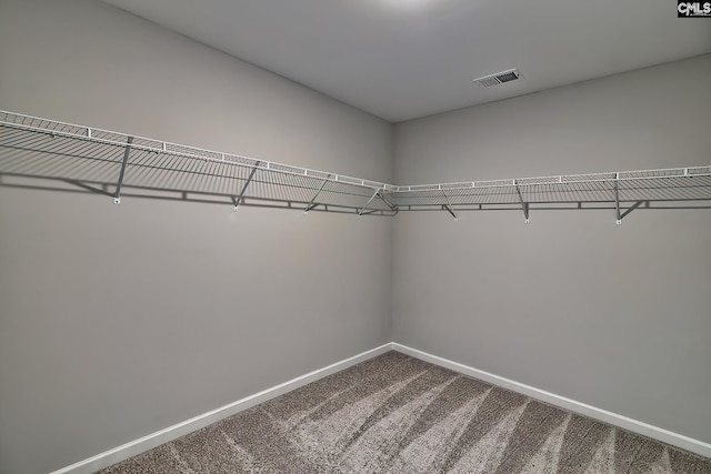 walk in closet with dark colored carpet and visible vents