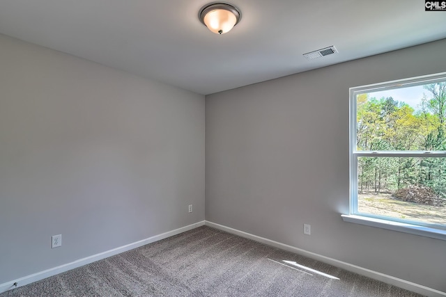 empty room featuring visible vents, baseboards, and carpet