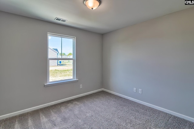 unfurnished room with carpet flooring, visible vents, and baseboards