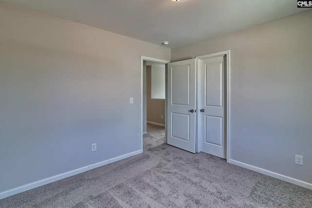 unfurnished bedroom featuring a closet, carpet flooring, and baseboards