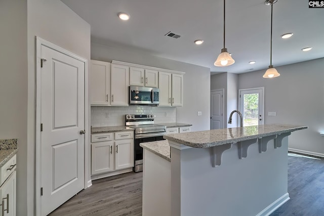 kitchen featuring visible vents, decorative backsplash, dark wood-type flooring, appliances with stainless steel finishes, and white cabinetry