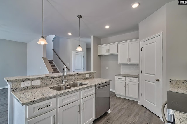 kitchen with a sink, decorative light fixtures, stainless steel dishwasher, wood finished floors, and white cabinets