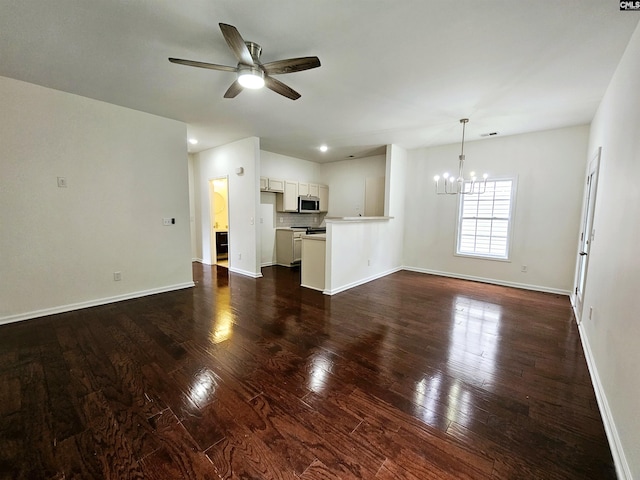 unfurnished living room featuring baseboards, dark wood finished floors, and ceiling fan with notable chandelier