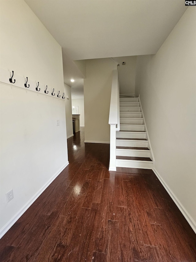 stairs with wood finished floors and baseboards