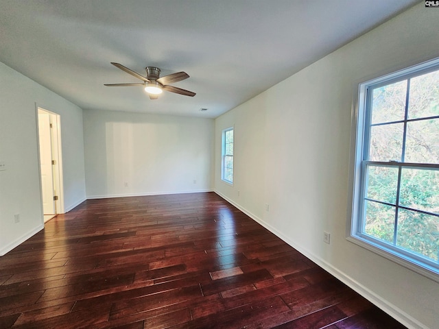 unfurnished room with dark wood finished floors, visible vents, baseboards, and ceiling fan