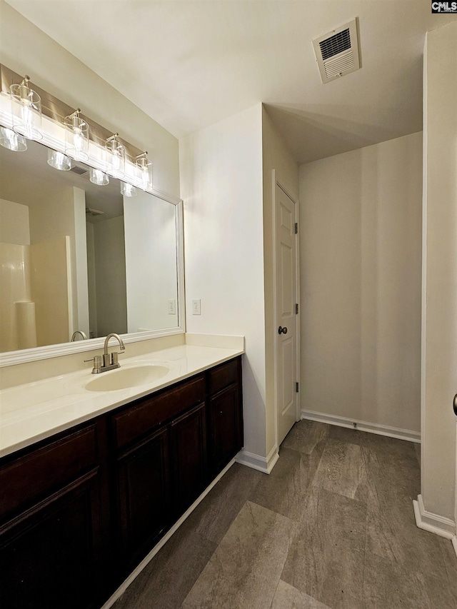 bathroom with visible vents, vanity, and baseboards