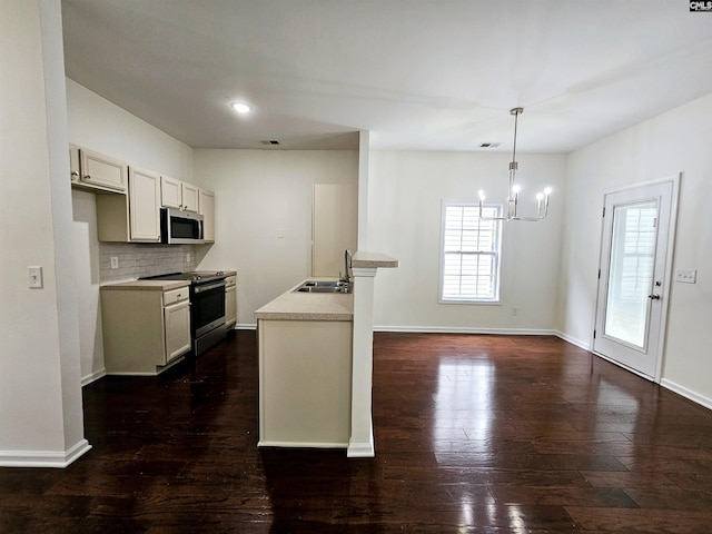 kitchen featuring decorative backsplash, appliances with stainless steel finishes, dark wood-style flooring, and a sink