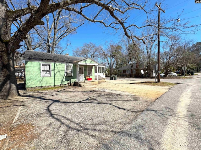 view of front of home featuring cooling unit and driveway