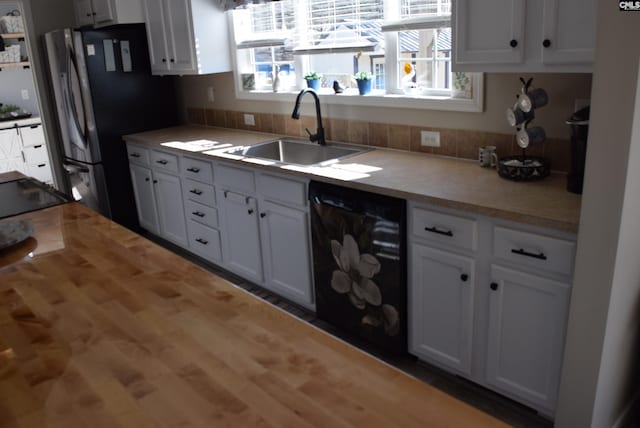 kitchen featuring a sink, black dishwasher, and white cabinetry