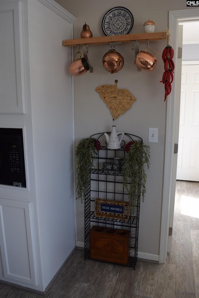 room details featuring wood finished floors, baseboards, and black microwave