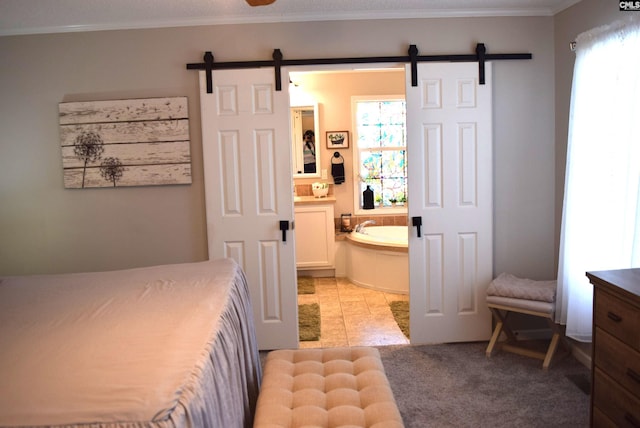 bedroom with a barn door, multiple windows, and ornamental molding