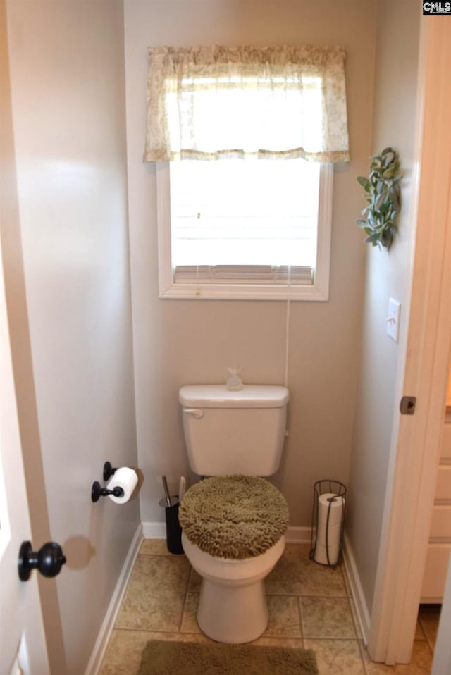 bathroom with tile patterned floors, toilet, and baseboards