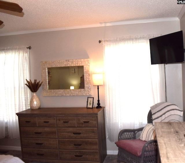 bedroom with baseboards, a textured ceiling, crown molding, and ceiling fan