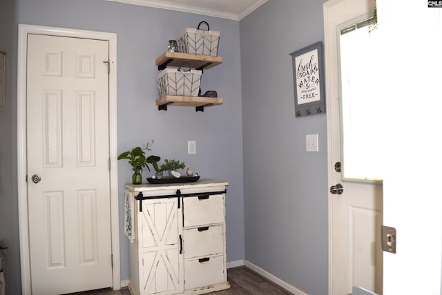 doorway to outside with dark wood finished floors, baseboards, and ornamental molding