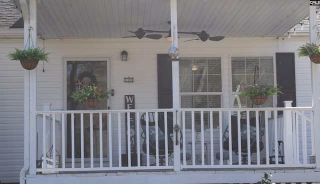 view of exterior entry with a porch and ceiling fan