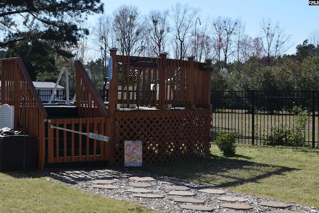 view of gate with a yard, fence, and a wooden deck