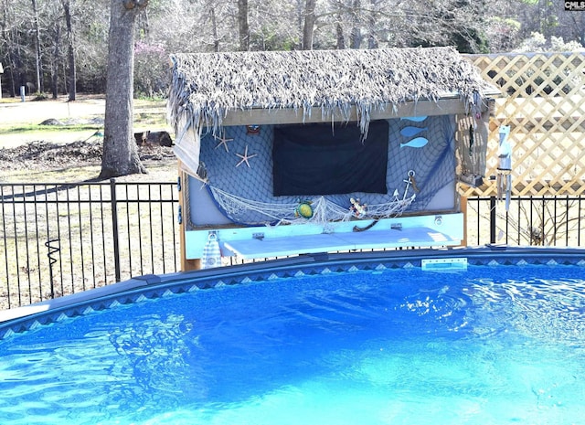 view of pool featuring a jacuzzi and fence