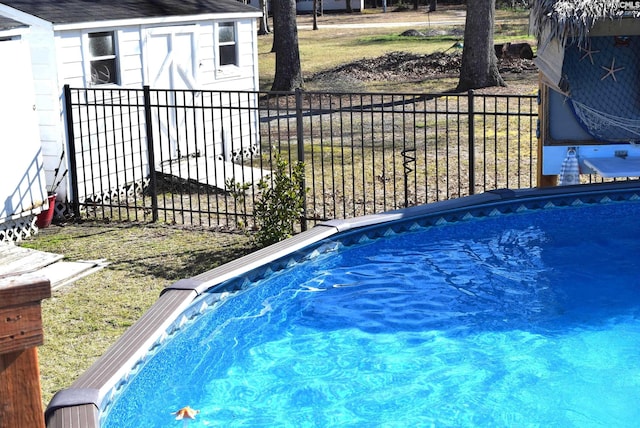 view of swimming pool with an outdoor structure and fence