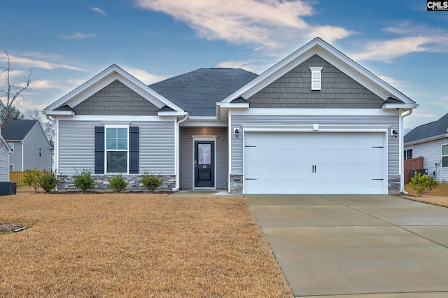 craftsman-style house with driveway, an attached garage, a front lawn, and a shingled roof