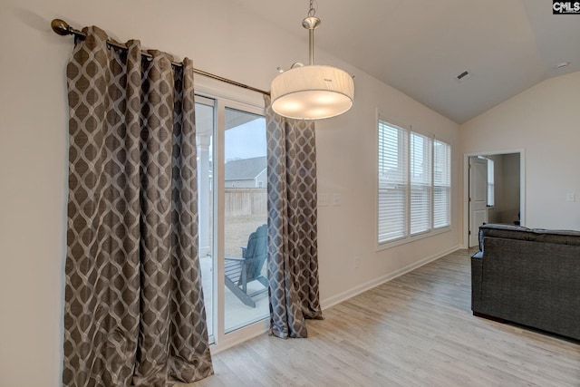 dining space featuring lofted ceiling, light wood-style floors, visible vents, and baseboards