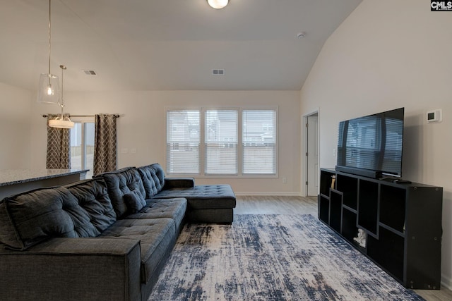 living room with visible vents, baseboards, wood finished floors, and vaulted ceiling