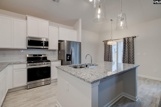 kitchen featuring backsplash, light wood-type flooring, appliances with stainless steel finishes, and a sink