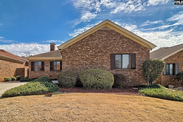 view of home's exterior featuring brick siding and a chimney