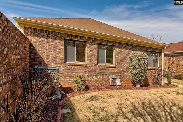 view of side of home featuring crawl space, brick siding, central AC, and a shingled roof