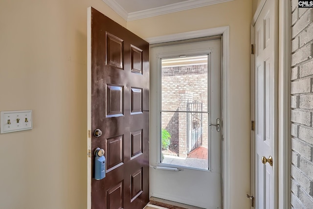 entrance foyer with brick wall and crown molding