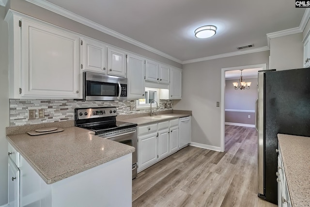 kitchen featuring visible vents, a sink, ornamental molding, stainless steel appliances, and white cabinets