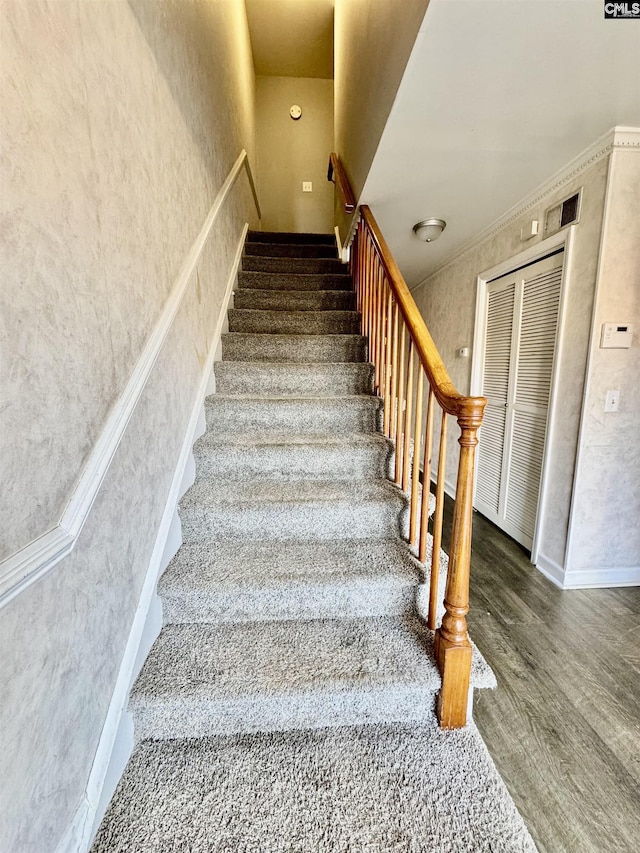 stairway with elevator, wood finished floors, and baseboards