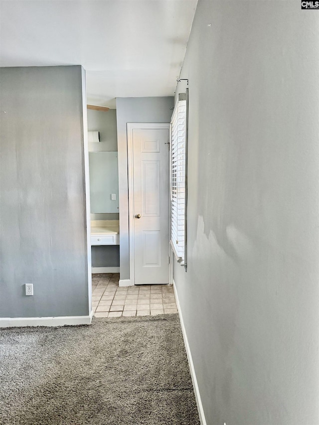 unfurnished bedroom featuring tile patterned flooring, baseboards, and carpet floors