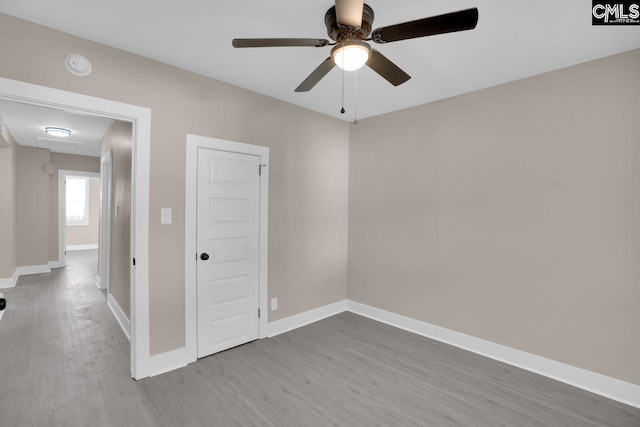 unfurnished room featuring ceiling fan, baseboards, and wood finished floors